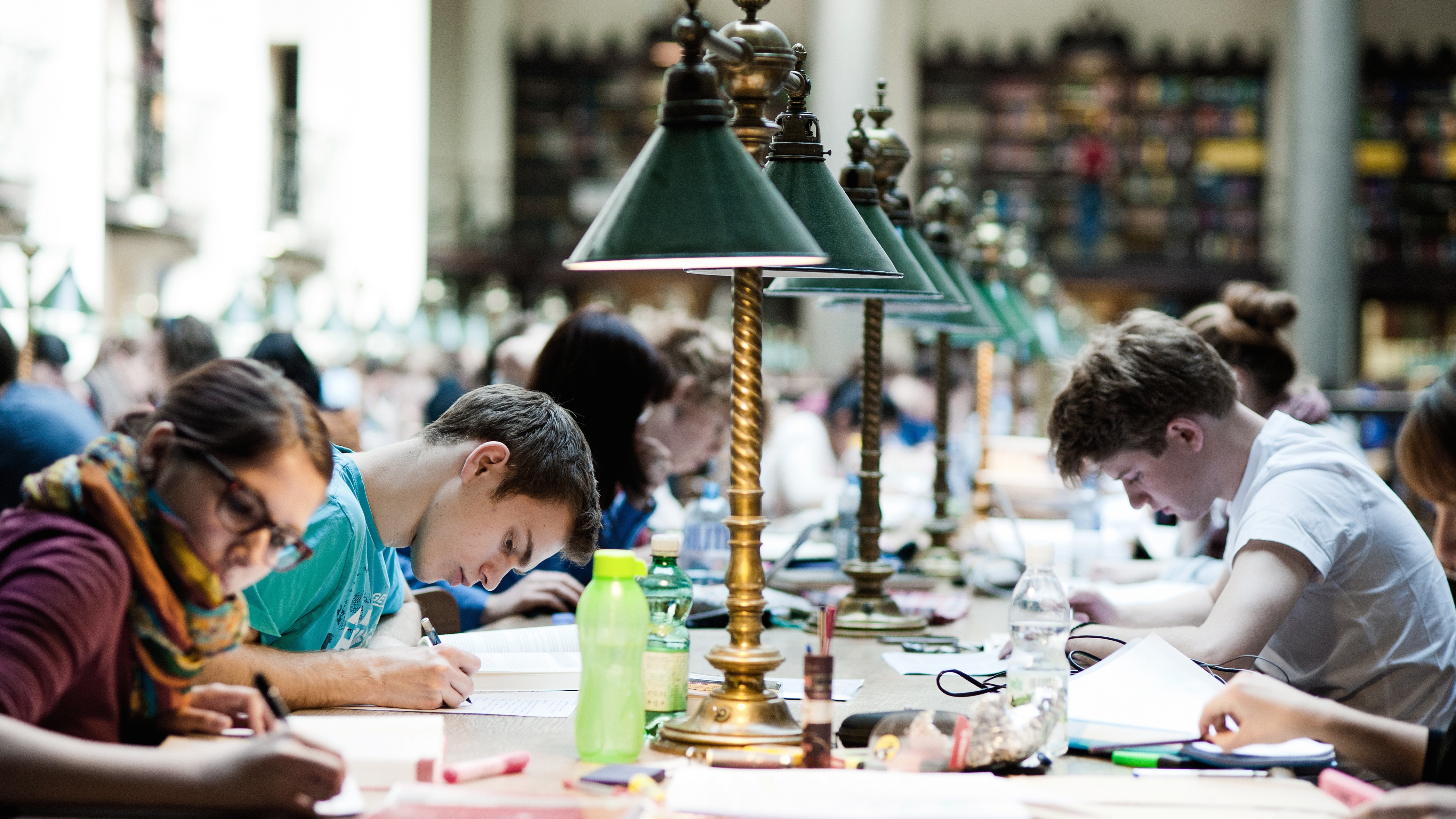 Studierende sitzen über ihre Lernmaterialien gebäugt im Hauptlesesaal der Uni Wien